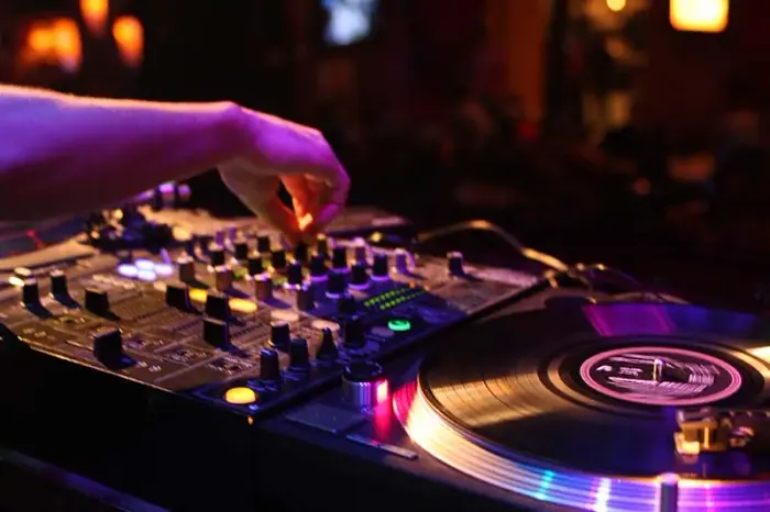 DJ står ved DJ-pult og spiller musik til firmafester.